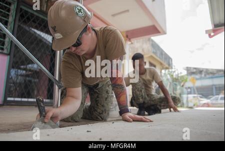 180424-N-OU TAWAU129-091, Malaysia (24 aprile 2018) Builder di terza classe autunno Williams di Naval Mobile Battaglione di costruzione (NMCB) 5 e una malese per le forze armate degli Stati applicano boiacca per un pavimento di calcestruzzo in un progetto di ingegneria a SK Kebangsaan Taman in Tawau, Malaysia come parte del partenariato Pacifico 2018 (PP18), 24 aprile 2018. PP18's missione è lavorare collettivamente con host e nazioni partner per migliorare l'interoperabilità a livello regionale di emergenza e capacità di risposta, aumentando la stabilità e la sicurezza nella regione e favorire la nascita di nuove e durature amicizie in tutta la regione Indo-Pacifico. Pacifi Foto Stock