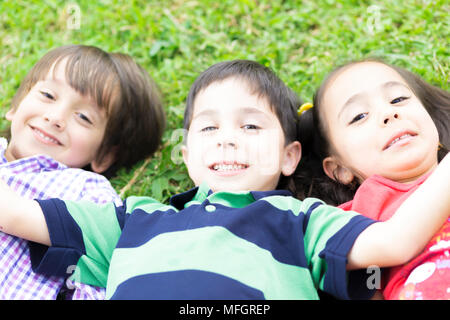 Felici i bambini che si divertono sull'erba nel parco Foto Stock