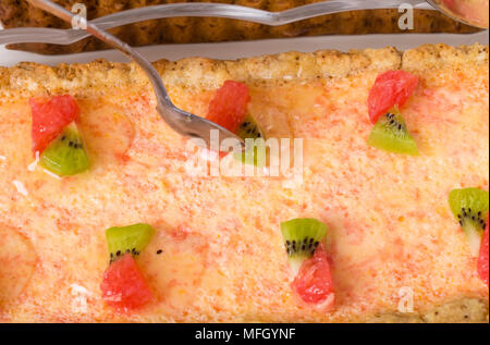 Aggiunta di sciroppo alla deliziosa crostata di pompelmo closeup. Macro. Foto può essere usato come un intero sfondo. Foto Stock