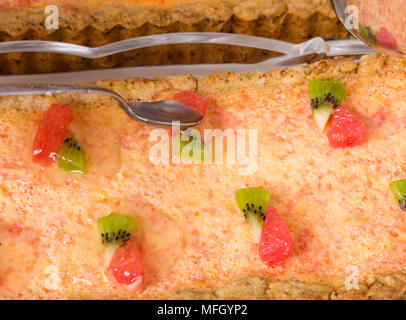 Aggiunta di sciroppo alla deliziosa crostata di pompelmo closeup. Macro. Foto può essere usato come un intero sfondo. Foto Stock