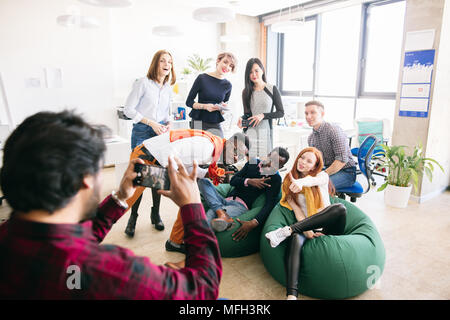 Elegante diversi giovani studenti sono in posa per la telecamera per la giornalista in maglietta controllato in camera con soppalco interno Foto Stock