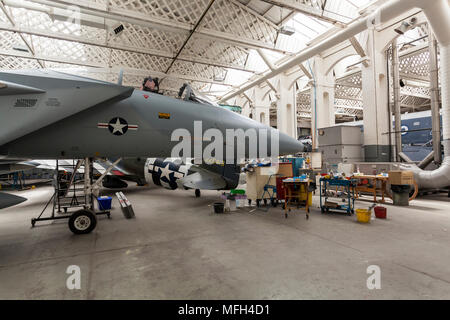 Duxford Air Museum. Inghilterra, Regno Unito. Diversi aeromobili nel museo appendiabiti's workshop per mainenance. Foto Stock