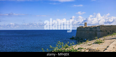 La Valletta, Malta. Cielo blu e vista sul mare oltre il muro di fortificazione, giornata di sole con poche nuvole Foto Stock