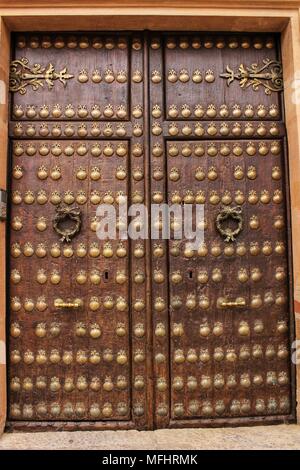 La vecchia porta con golden particolari in ferro battuto con figure di gusci. Rusty e blocco di antiquariato nell'angolo. Foto Stock