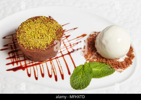 Brownie al cioccolato torta con gelato alla vaniglia sulla piastra bianca, primo piano Foto Stock