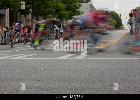Motion Blur dei maschi di ciclisti ruotando di un angolo in una gara amatoriale in Atene annuale Twilight criterium in Atene, GA il 25 aprile 2015. Foto Stock