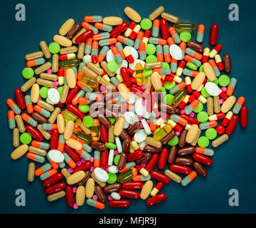 Pila di coloratissimi compresse e capsule pillole su sfondo blu. La resistenza agli antibiotici e il consumo di stupefacenti con il concetto di ragionevole. Industria farmaceutica. G Foto Stock