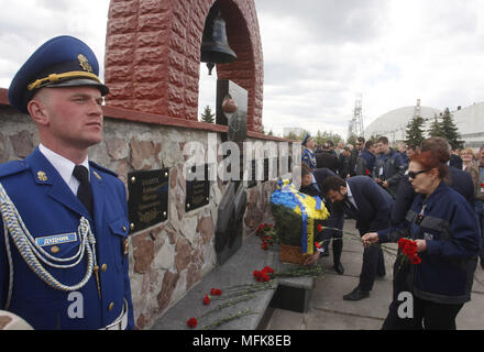 Kiev, Ucraina. 26 apr, 2018. Cernobyl lavoratori fiori di laici per il monumento in onore di coloro che sono stati uccisi nella centrale nucleare di Cernobyl disastro, durante una cerimonia di Chernobyl, regione di Kiev, Ucraina, il 26 aprile 2018. Gli ucraini contrassegnare la 32th anniversario del disastro di Chernobyl la tragedia. L'esplosione dell'unità 4 della centrale nucleare di Chernobyl il 26 aprile 1986 è ancora considerato il più grande incidente nella storia dell energia nucleare. Credito: Serg Glovny/ZUMA filo/Alamy Live News Foto Stock