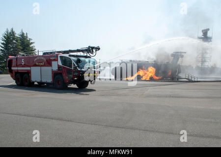 Gli esecutori dell'OSU Tour primaverile a turno cercando di estinguere un aereo simulato incendio presso Yokota Air Base, Giappone, 22 aprile 2018. Il tour, ospitato dal gen. Paolo Selva, Vice Presidente del Comune di capi di Stato Maggiore, incluso scrittore e comico Jon Stewart, country music artist e U.S. Esercito veterano Craig Morgan, celebrity chef Robert Irvine, UFC fighters Paige VanZant e Max Holloway, nonché pensionati giocatori NBA Richard "Rip" Hamilton. (U.S. Air Force Foto di Airman 1. Classe Matthew Gilmore) Foto Stock