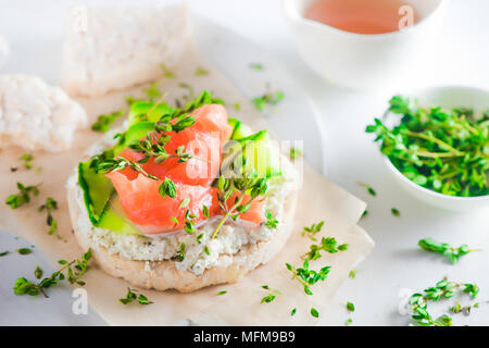 Pane croccante snack sani con salmone, ricotta, strisce di cetriolo, il timo e il pepe. Colazione semplice concetto di close-up con copia spazio. Foto Stock