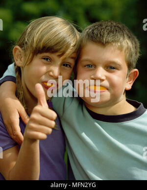 Ritratto di un ragazzo facendo una faccia con una ragazza che mostra un pollice in alto segno Ref: CRB342 10012 071 Credito obbligatoria: Peter Muller/Photoshot Foto Stock