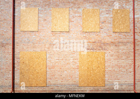 Incompiuta casa in mattoni rossi con facciata di truciolato di legno ricoperto di windows. Foto Stock