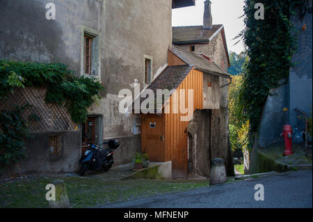 Blue bici del motore nella parte anteriore della costruzione in pietra con orange estensione di legname. Pittoresca stradina a Friburgo città medievale, Svizzera Foto Stock