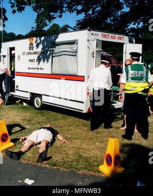 L'uomo che giace piatto fuori accanto a un St John Ambulance ad un festival in Preston Park, Brighton East Sussex, Regno Unito. Ref: CRB459 103533 0007 CRE OBBLIGATORIA Foto Stock