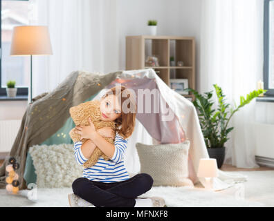 Carino bambina abbracciando Teddy bear a casa Foto Stock