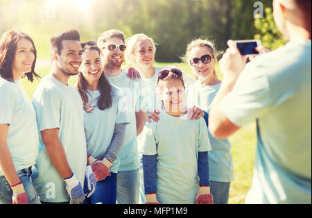 Gruppo di volontari di scattare una foto tramite smartphone Foto Stock