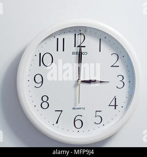 Primo piano della faccia del moderno stile orologio mostra bianco rotondo e quadrante nero al momento ore 3 su sfondo bianco Foto Stock