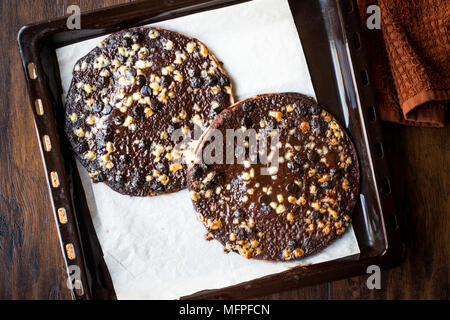 Pizza al cioccolato con il cioccolato bianco palle nel vassoio da forno. Concetto di dessert. Foto Stock