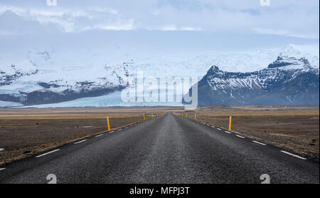 Strada che conduce verso il grande ghiacciaio e le montagne in Islanda Foto Stock