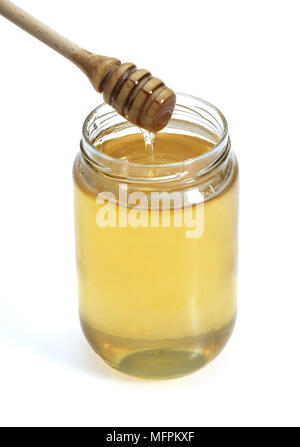 Un vasetto di miele con cucchiaio di miele contro uno sfondo bianco Foto Stock