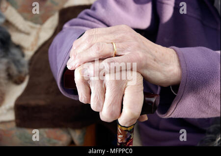 Donna anziana le mani tenendo un bastone da passeggio il modello di rilascio Foto Stock