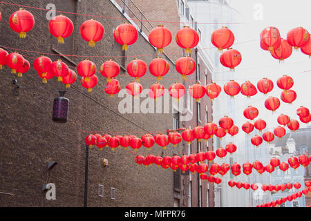 Lanterne rosse appendere al di sopra della strada, infilate tra gli edifici, a Londra Regno Unito il quartiere Chinatown nella celebrazione del Capodanno cinese Foto Stock