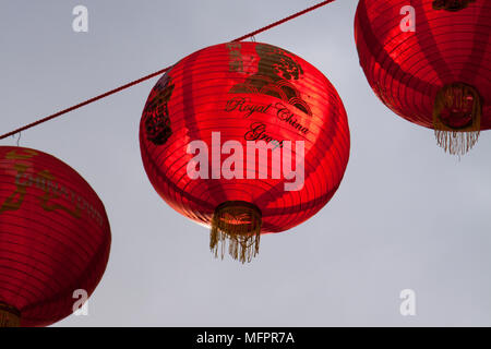 Lanterne rosse appendere al di sopra della strada, infilate tra gli edifici, a Londra Regno Unito il quartiere Chinatown nella celebrazione del Capodanno cinese Foto Stock