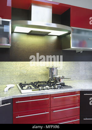 Piano di cottura impostato nel piano di lavoro in rosso e nero con cucina dotata di unità Foto Stock