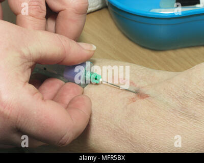 Donna anziana avente un esame di sangue prelevato (esami del sangue sono ora una funzione periodica per il monitoraggio di diverse condizioni) Foto Stock