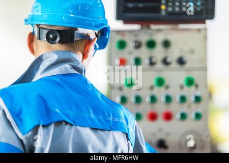 Macchinari per la console operatore. Caucaso in linea di produzione tecnico nella parte anteriore del pannello di controllo della macchina Foto Stock