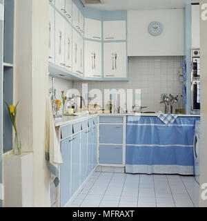 Cucina con blu e bianco unità di credenza e pareti piastrellate Foto Stock