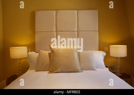 letto matrimoniale con testiera, cuscini e copertura grigia in camera  d'hotel Foto stock - Alamy