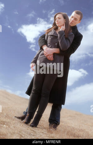 Un uomo abbraccia la sua ragazza in un prato Foto Stock