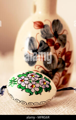 Appendere brown dipinte a mano e ceca uovo di Pasqua. Un tradizionale hndpainted marrone ceco uovo di pasqua si blocca prima di una caraffa. l'uovo è con una cipolla tradizionale Foto Stock