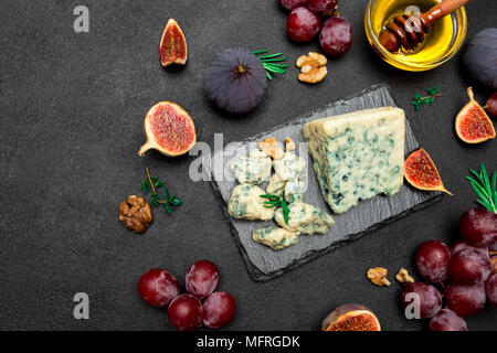 Fetta di Francese Roquefort formaggio e frutta sulla scheda di pietra Foto Stock