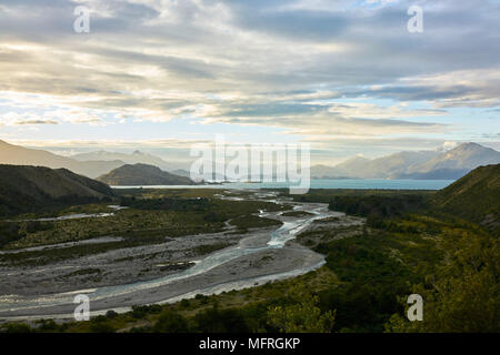 Chacabuco fiume che scorre in Carretera Lago in Patagonia cilena. La cordigliera delle Ande montagne in distanza. Una splendida cloudscape sopra. Foto Stock