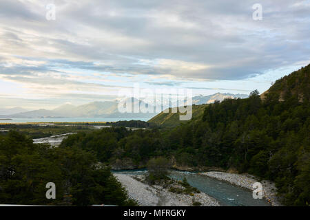 Chacabuco fiume che scorre in Carretera Lago in Patagonia cilena. La cordigliera delle Ande montagne in distanza. Una splendida cloudscape sopra. Foto Stock