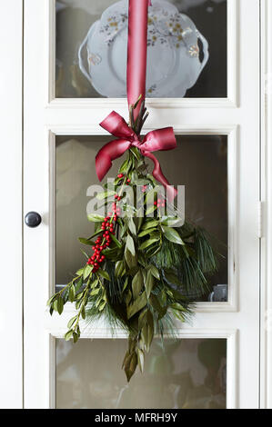 Foglie di Natale appeso al nastro rosa nella parte anteriore del vetro della porta del cabinet, Fairfield, New Jersey, STATI UNITI D'AMERICA Foto Stock