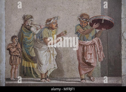 Commedia scena raffigurata nel mosaico romano da Villa de Cicero (Villa di Cicerone) a Pompei, ora esposti nel Museo Archeologico Nazionale (Museo Archeologico Nazionale di Napoli) in Napoli, campania, Italy. Musicisti di strada sono raffigurati suonare strumenti musicali spesso collegati con il culto di Cibele: tamburello, piccoli cembali e doppio flauto (tibia). Il mosaico raffigura un episodio da una commedia, poiché le cifre sono indossare maschere teatrali. Foto Stock