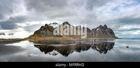 La riflessione di acqua presso la spiaggia di sabbia nera, montagne Klifatindur, Eystrahorn e Kambhorn, Stokksnes operazioni automatiche di fine campo Foto Stock