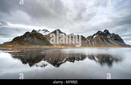 La riflessione di acqua, montagne Klifatindur, Eystrahorn e Kambhorn, Stokksnes capezzagna, Klifatindur mountain range, Regione orientale Foto Stock