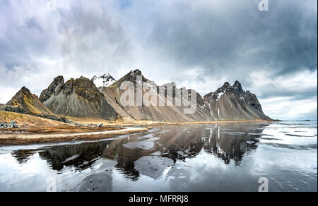 La riflessione di acqua, montagne Klifatindur, Eystrahorn e Kambhorn, Stokksnes capezzagna, Klifatindur mountain range, Regione orientale Foto Stock