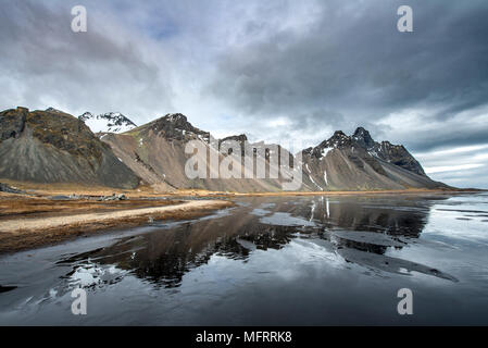 La riflessione di acqua, montagne Klifatindur, Eystrahorn e Kambhorn, Stokksnes capezzagna, Klifatindur mountain range, Regione orientale Foto Stock