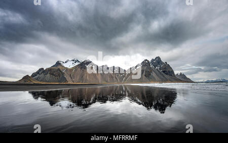 La riflessione di acqua, montagne Klifatindur, Eystrahorn e Kambhorn, Stokksnes capezzagna, Klifatindur mountain range, Regione orientale Foto Stock