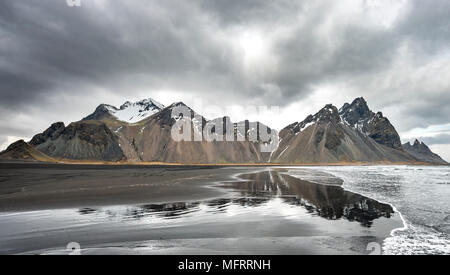 La riflessione di acqua, montagne Klifatindur, Eystrahorn e Kambhorn, Stokksnes capezzagna, Klifatindur mountain range, Regione orientale Foto Stock