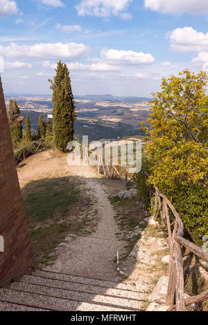 Strada di campagna con cipressi sulle colline vicino a Montalcino. Siena, Toscana, Italia Foto Stock