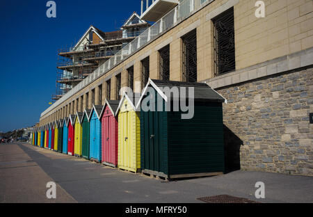 Una linea colorata colorata bloccato e spiaggia vuota di capanne a Boscombe parte della spiaggia di Bournemouth Dorset in Inghilterra. Foto Stock