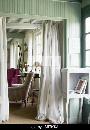 Stile gustaviano bianco tavola dipinta accanto alla porta con vista attraverso la stanza di seduta Foto Stock