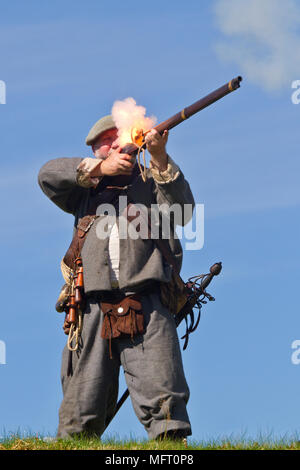 Un re-enactor sparare un moschetto nell'uniforme del xvii secolo covenanter del colonnello Hugh Fraser, dragoni. Foto Stock