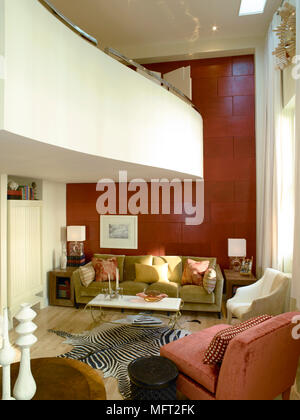 Moderno salotto rosso con parete di accento, curvando il balcone e area salotto con stampa animale rug. Foto Stock
